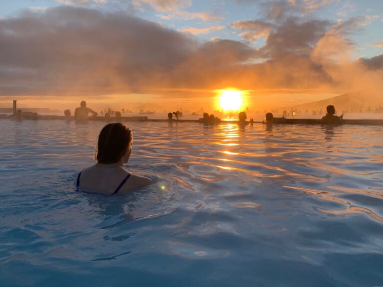 Vrouw in Myvatn Nature Baths, kijkend naar de zonsondergang, IJsland