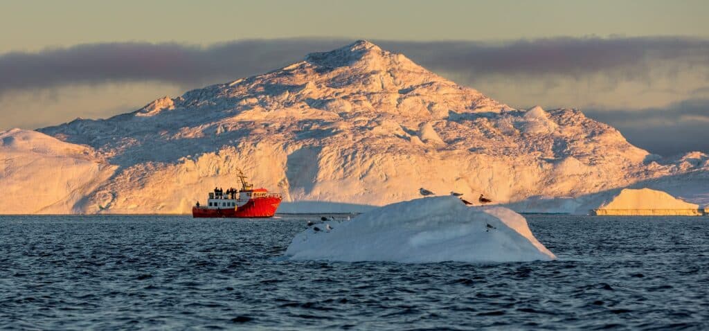 bootexcursie op groenland naar ijsbergen met ondergaande zon