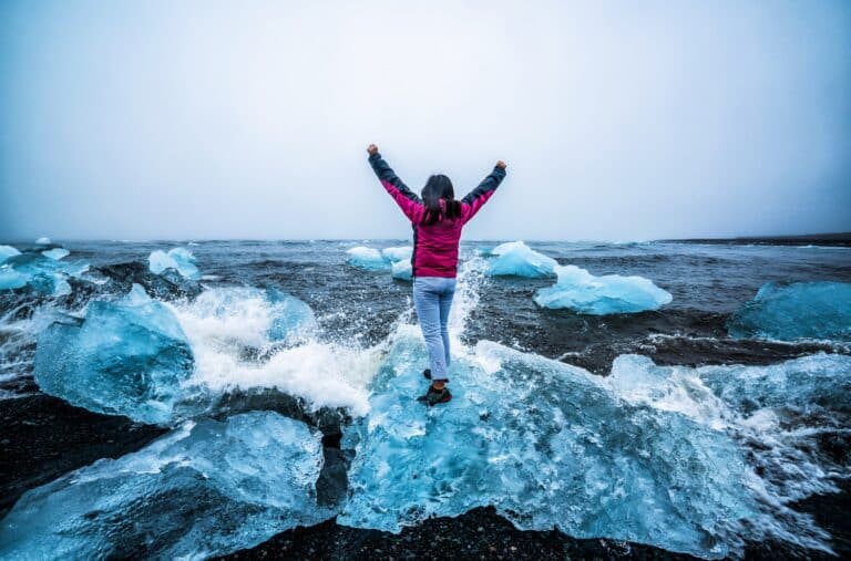 Diamond beach bij het ijsbergenmeer met vrouw op IJsland
