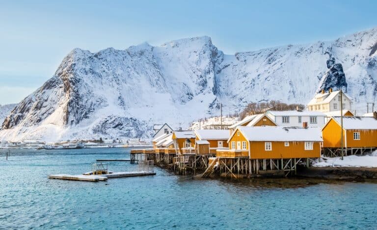 Gele rorbu huisjes omgeven door besneeuwde bergen