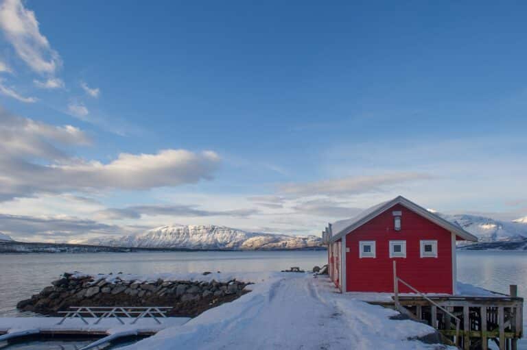 Zicht over Malangen vanaf een rood houten vissershut