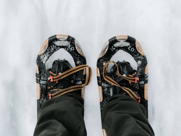 Foto van voeten in sneeuwschoenen in de sneeuw