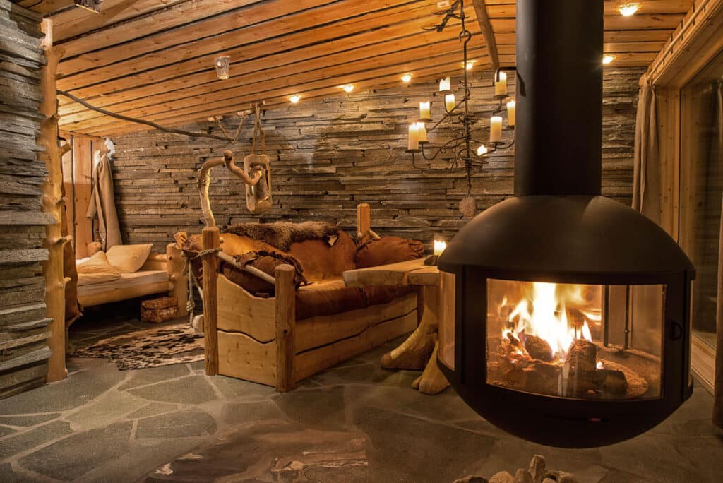 Het interieur van het zelfgebouwde houten huisje Raktu, met de houtkachel aan