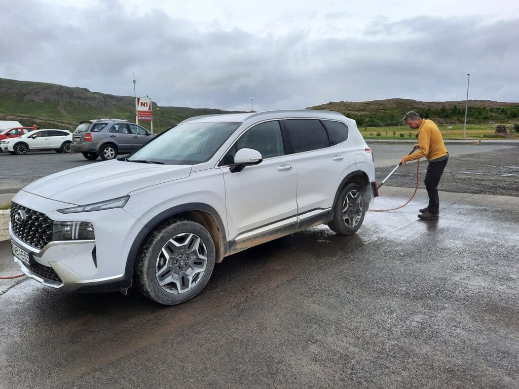 Man wast witte auto op IJsland