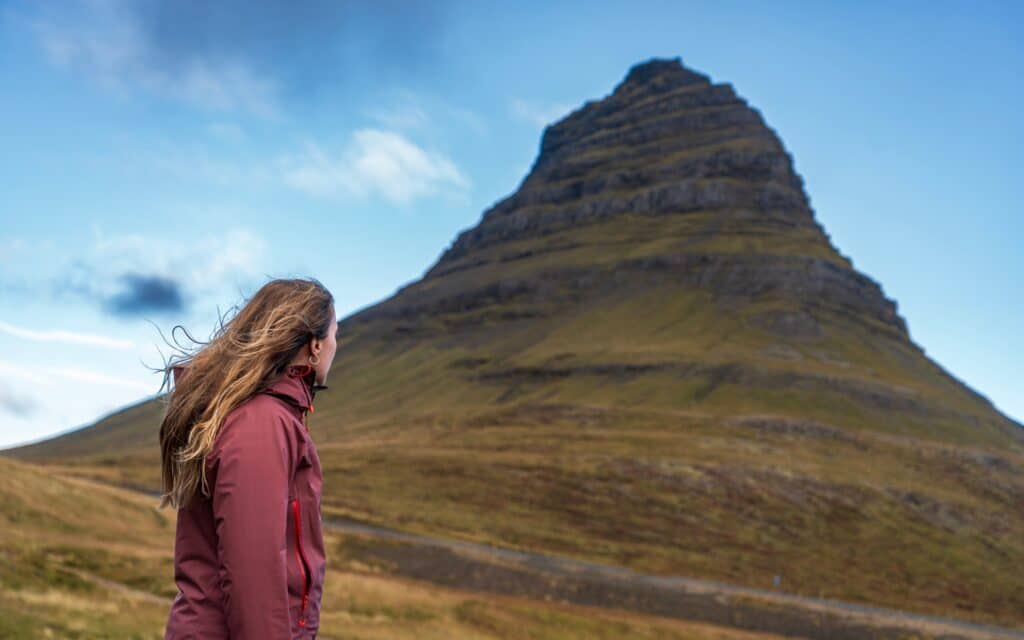 Vrouw staat voor Kirkjufell berg, Snaefellsnes, IJsland