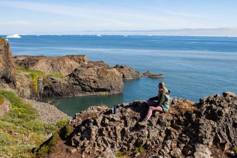 Vrouw kijkt uit over de Diskobaai, vanaf Kuannit, Groenland