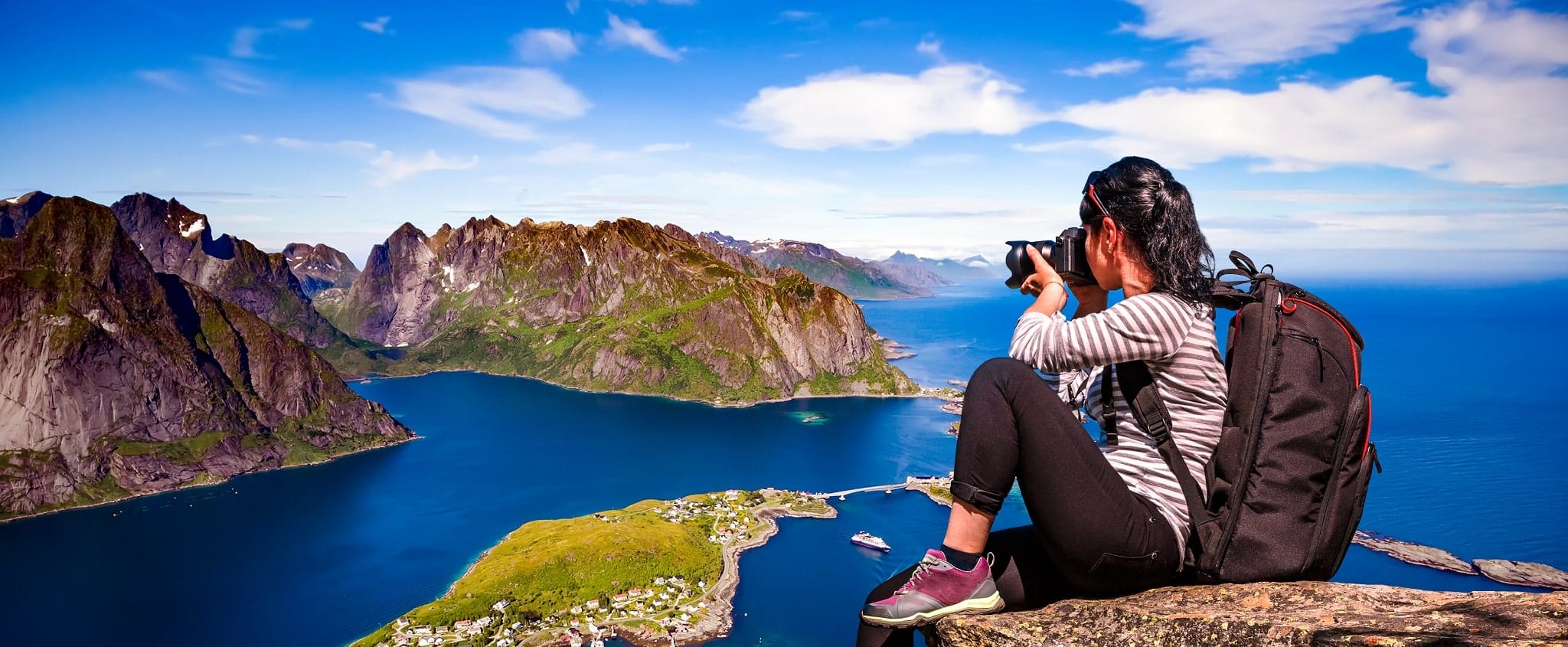 Lofoten, Noorwegen: vrouw fotografeert vanaf rots