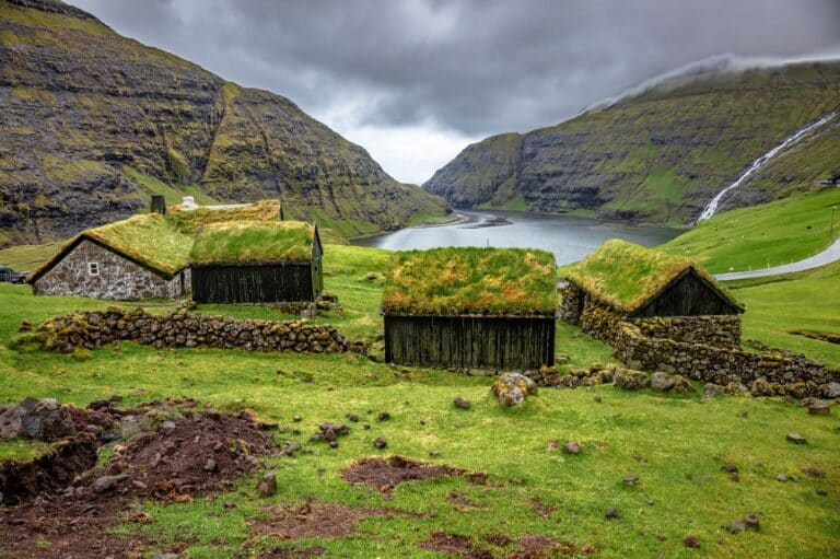 Uitzicht op fjord met huisjes met grasdaken vanuit Saksun, Faeröer eilanden