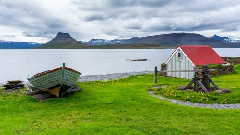 Huisje en boot aan het water op het eilandje Vigur, Westfjorden, IJsland