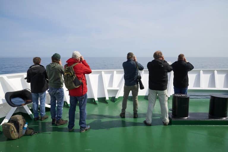 Mensen maken foto's van uitzicht op voordek van expeditie schip de Hondius