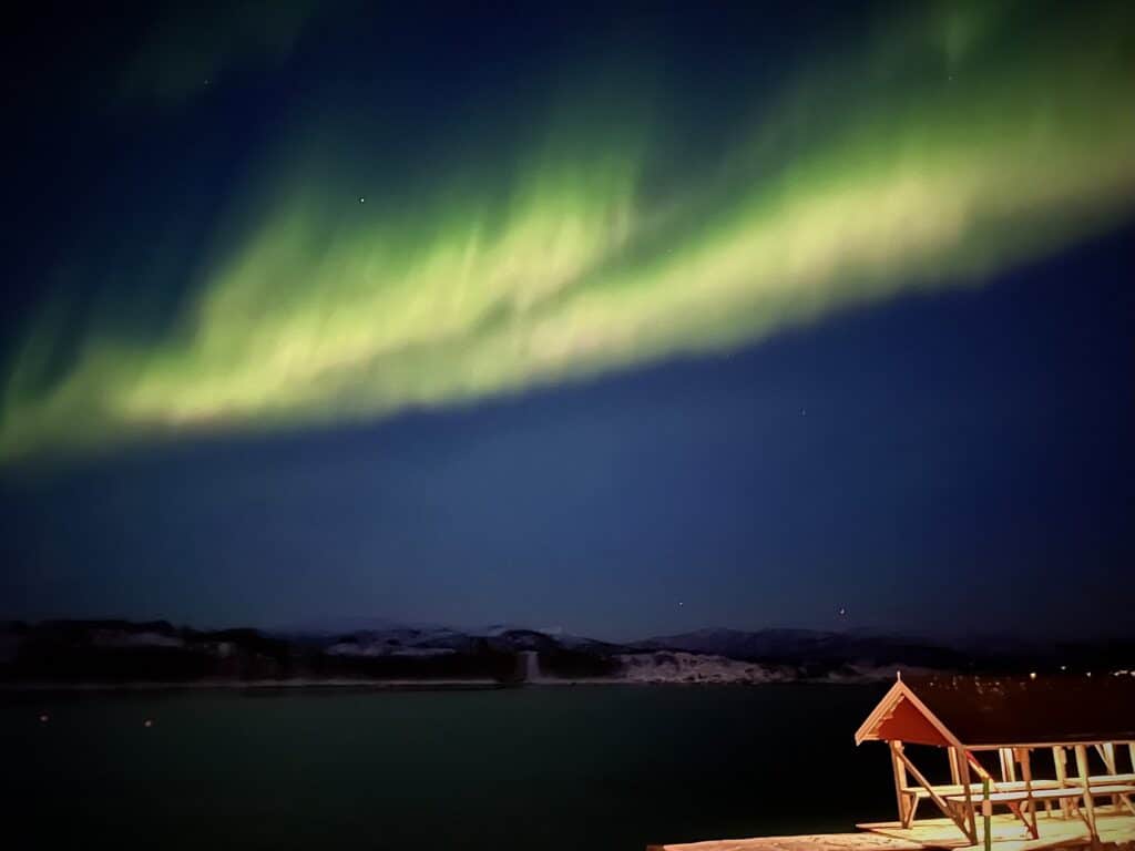 Noorderlicht boven rood houten huisje