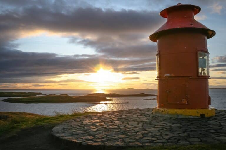 Vuurtoren met zonsondergang in Bredafjordur baai op IJsland