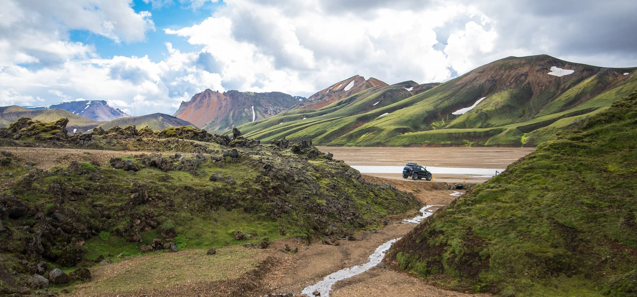 Auto rijdt over Landmannalaugar hooglandroute, IJsland