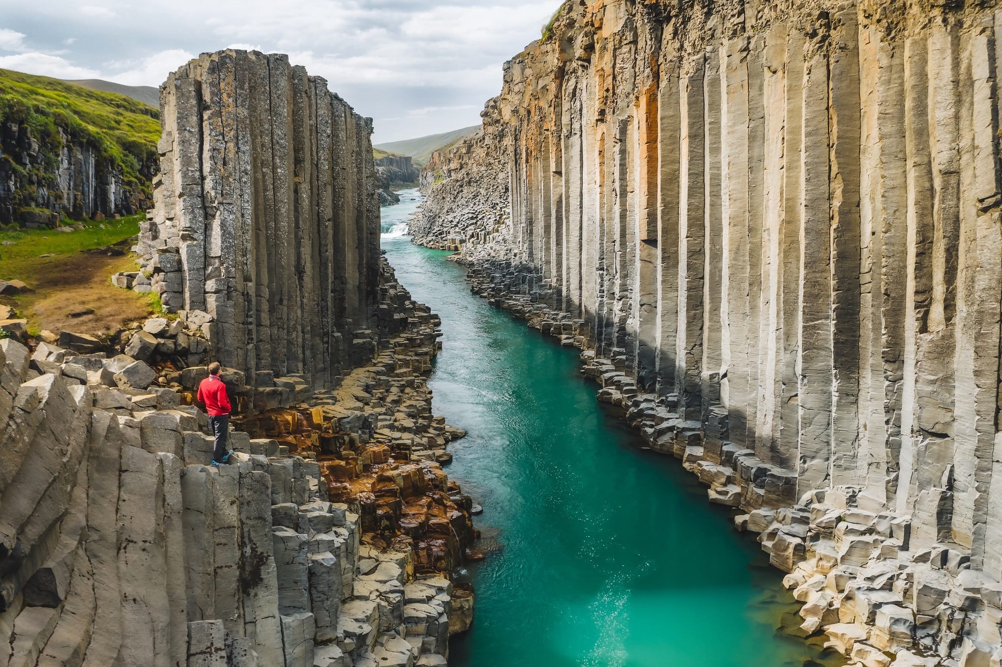 Man kijkt uit over Studlagil Canyon, met rivier en basaltkolommen, in Oost-IJsland