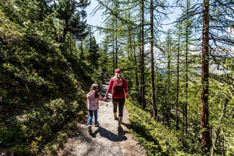 Moeder en kind wandelend door bos