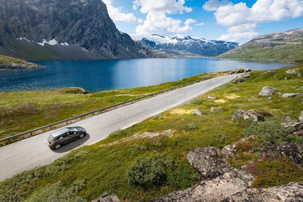 Auto rijdt lang fjord in Noorwegen.
