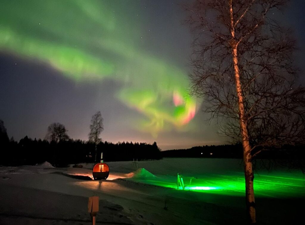 Noorderlicht boven barrel sauna bij hotel Metsahirvas in Fins Lapland
