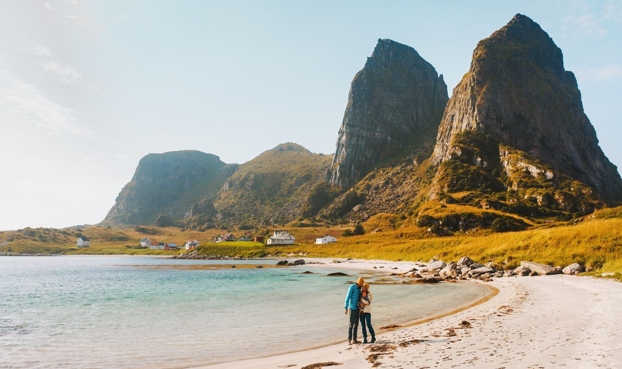 Koppel op strand in Helgeland met bergtoppen op achtergrond