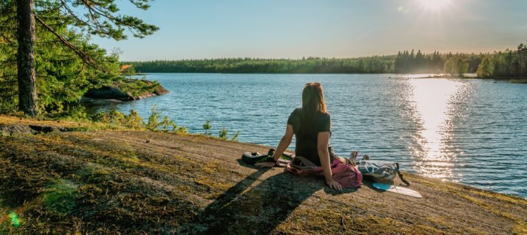 Vrouw kijkt uit over een meer in Zweden
