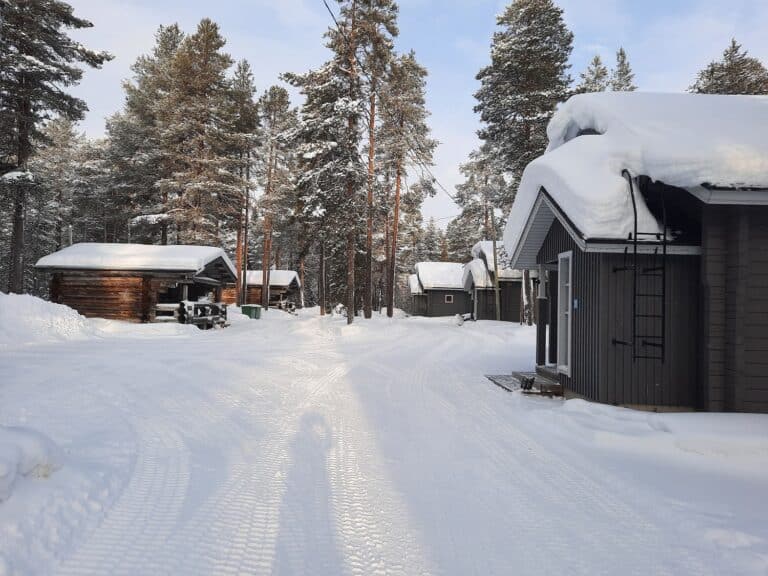Besneeuwd pad tussen huisjes Himmerki Lodge, Fins Lapland