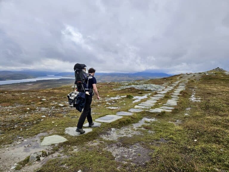 Man met kind in rugdrager wandelt Falkenuten Hike, Noorwegen