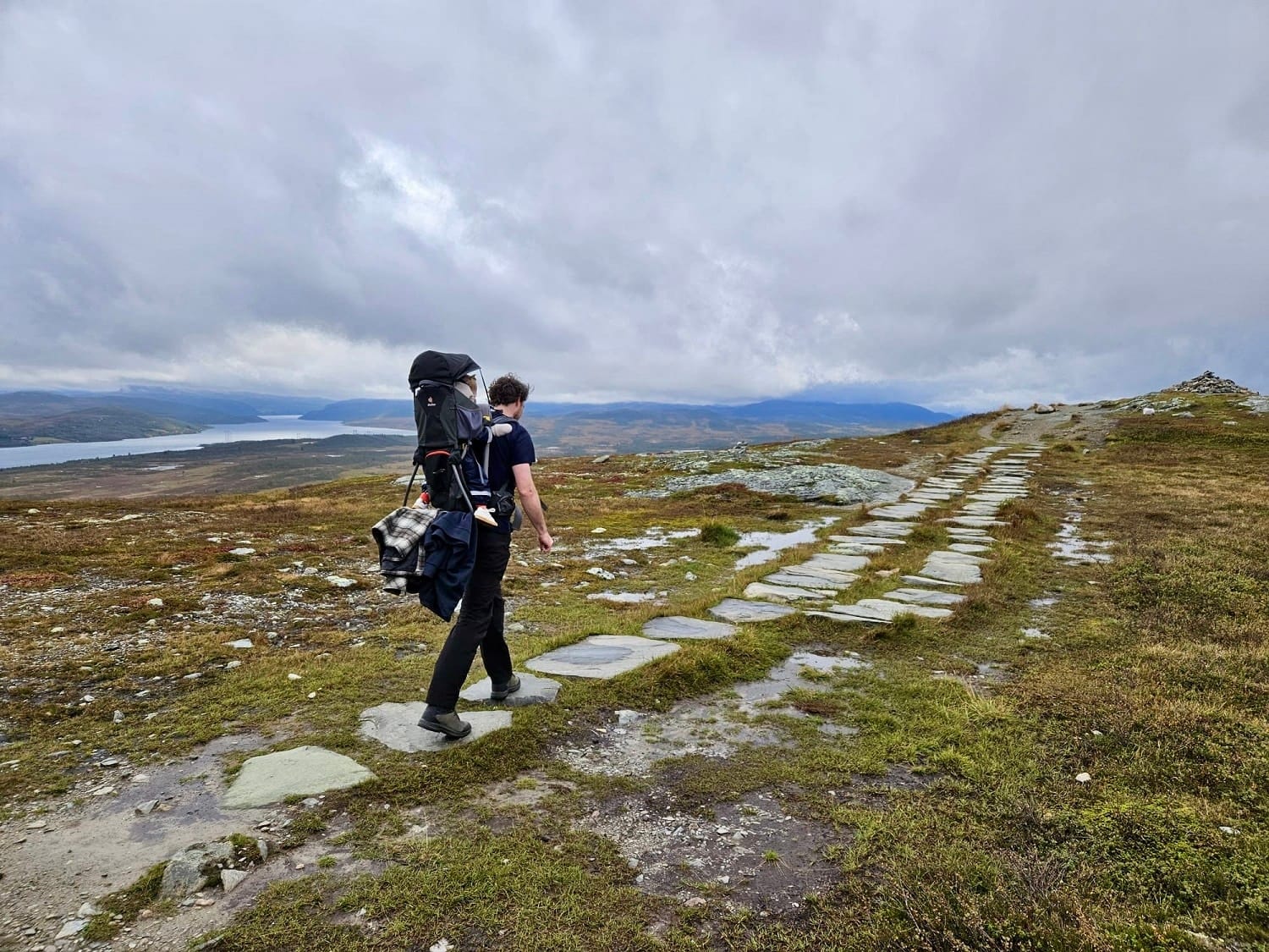 Man met kind in rugdrager wandelt Falkenuten Hike, Noorwegen