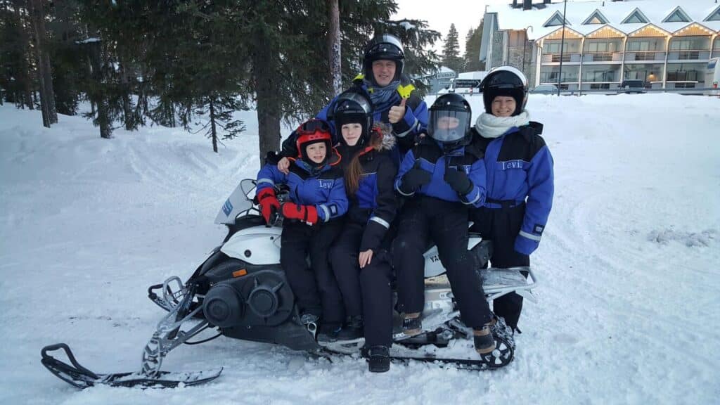 Familie op sneeuwscooter in Lapland