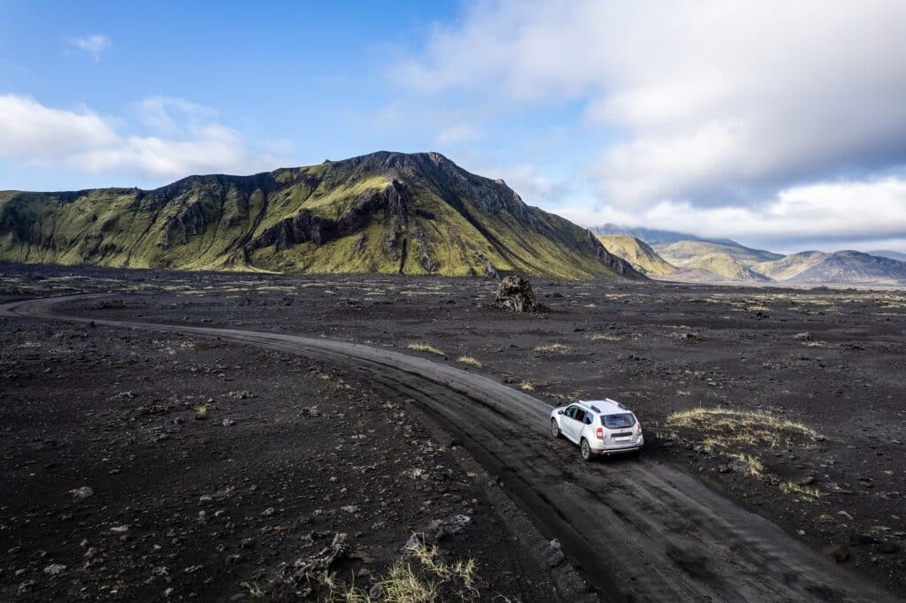 Auto rijdt door het binnenland van IJsland bij Landmannalaugar