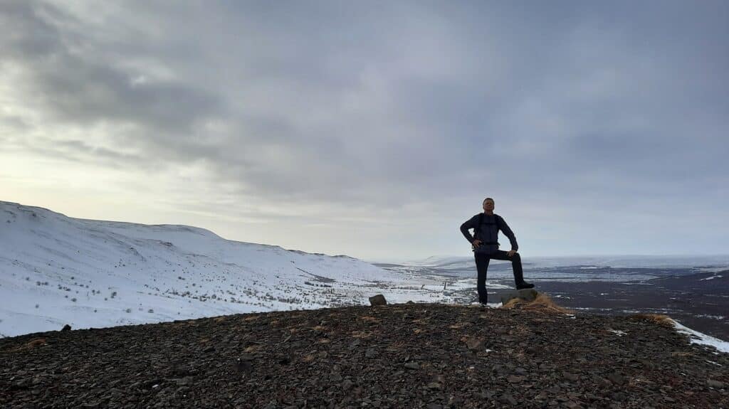Wandelaar poseert in winters landschap op IJsland