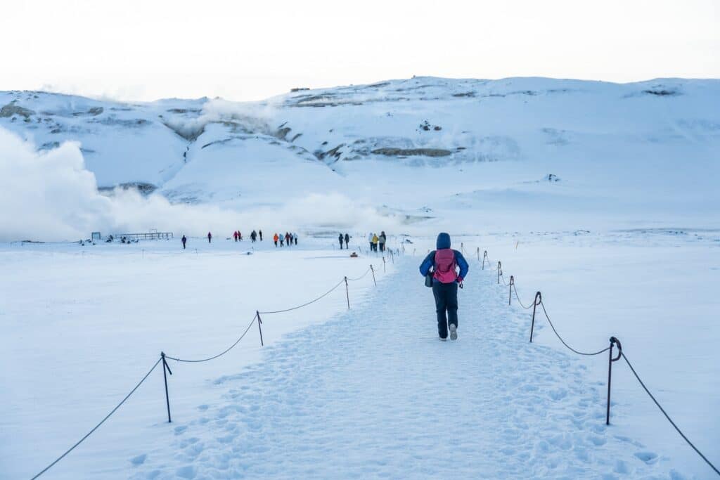 Wandelaar loopt over pad bij Hverir op IJsland in de winter