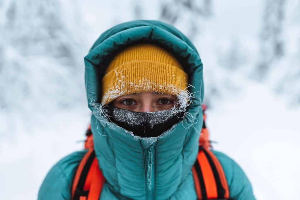 Vrouw dik ingepakt tegen de kou in winters landschap