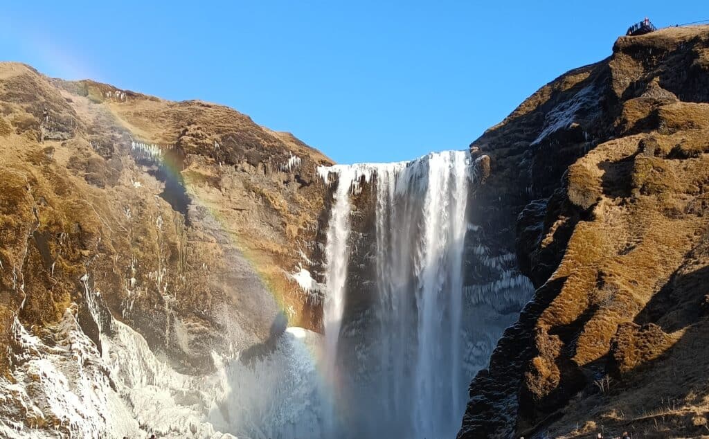 Skogafoss in de winter met regenboog ervoor.