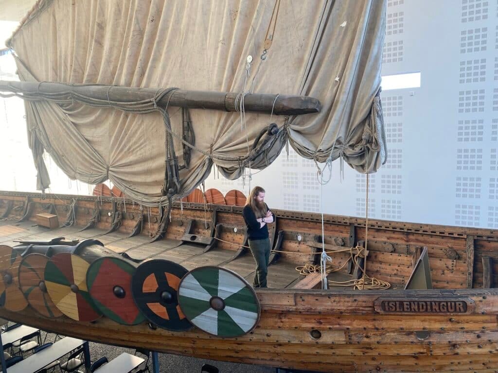 Man op replica vikingschip in Viking World Museum op IJsland