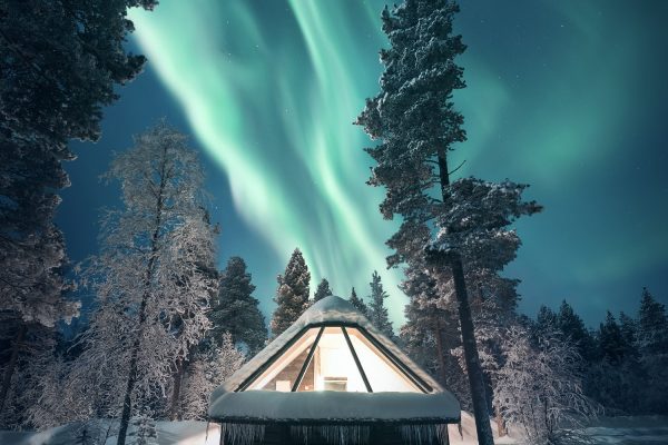 Aurora cabin met noorderlicht op de achtergrond aurora village