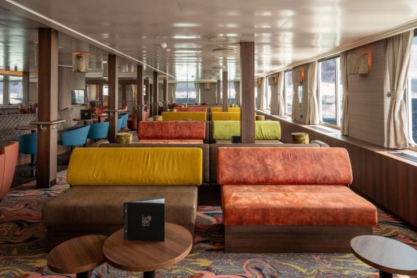 De lounge van expeditie schip de Hondius met grote ramen