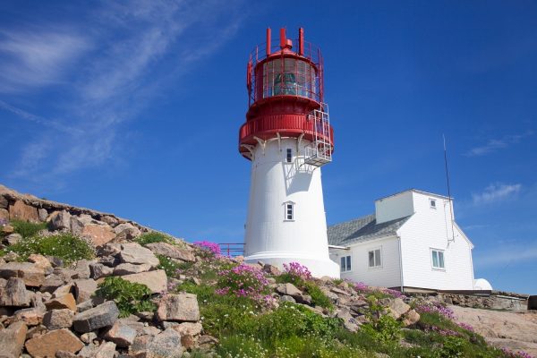 Wit-rode vuurtoren op de rotsachtige kust van Lindesnes