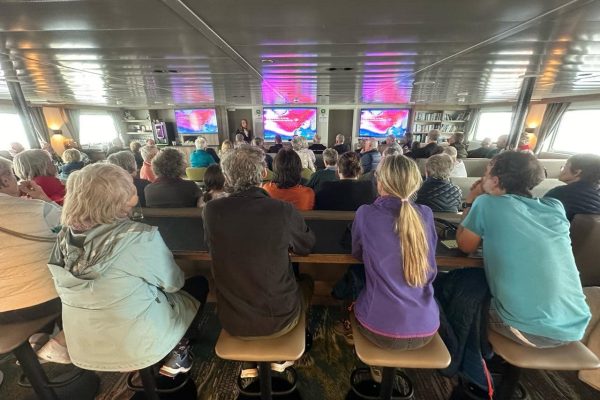 Mensen die luisteren naar de lezing op het expeditie schip Ortelius in de observatie lounge