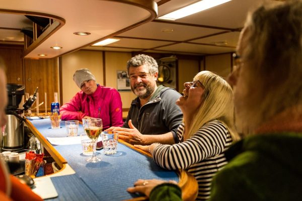 Mensen hebben plezier aan de bar op zeilschip De Rembrandt