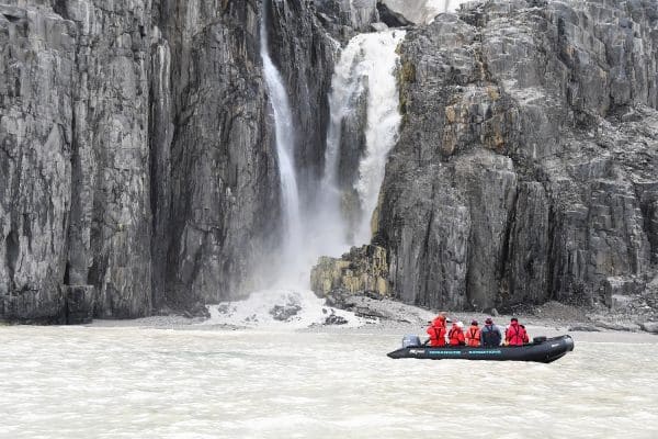 Zodiac cruise Alkefjellet in Spitsbergen met zicht op steile rotsen en waterval