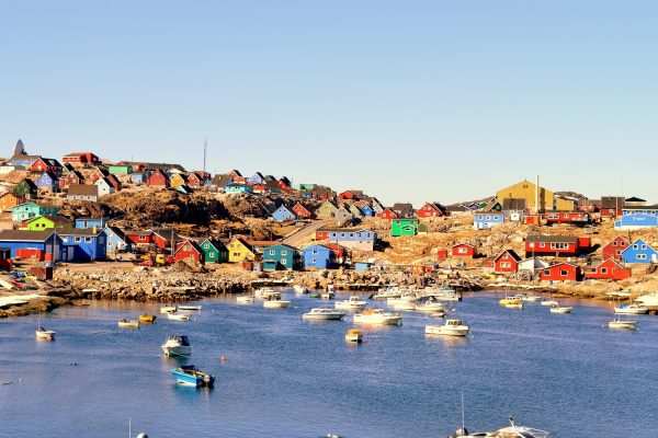 De haven en gekleurde huizen van het dorpje Aaisiaat in Groenland gezien vanaf zee