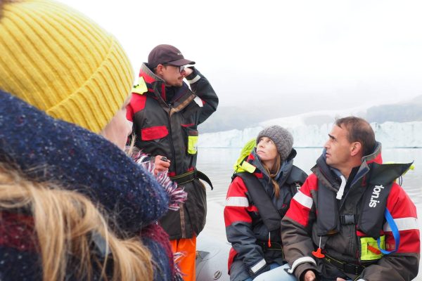 Mensen luisteren naar gids tijdens zodiac tour Fjallsarlon Glacier Lagoon op IJsland
