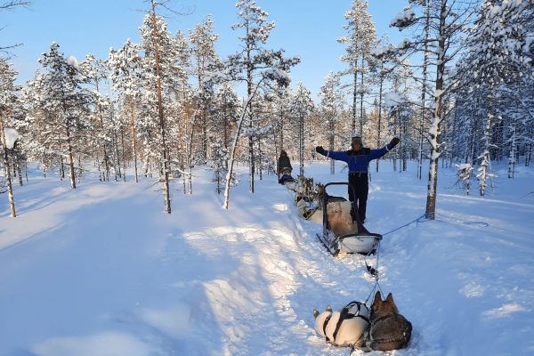 Man staat naast slede tijdens rustpauze husky safari