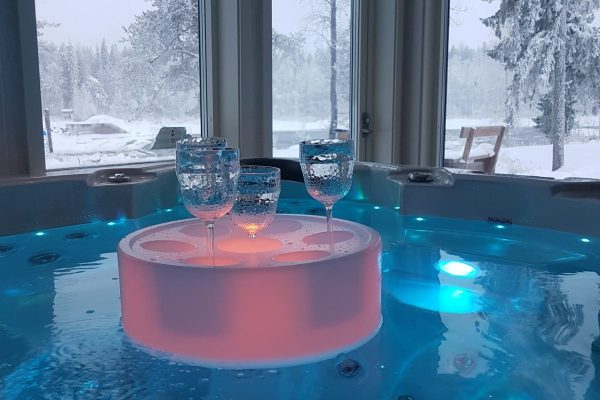 Drijvende glazen in een bubbelbad met sneeuw op de achtergrond