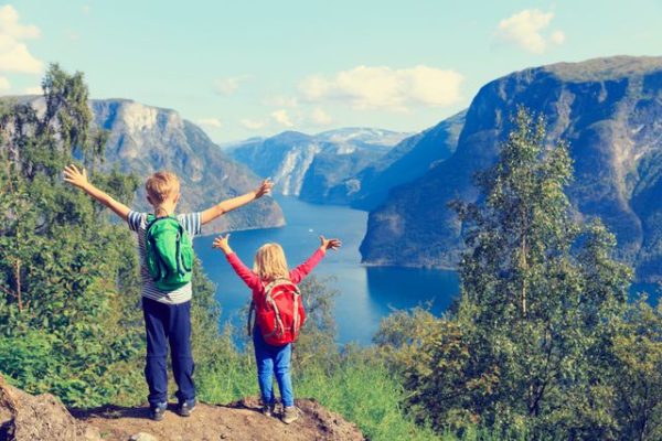 Blije kinderen uitkijkend over fjord in Noorwegen