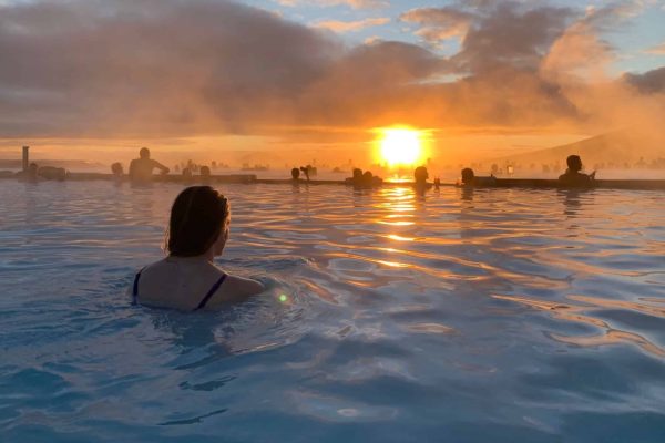 Vrouw in Myvatn Nature Baths, kijkend naar de zonsondergang, IJsland