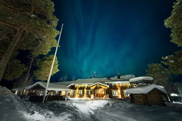 Hoofdgebouw van Nellim Wilderness Hotel in Fins Lapland met het noorderlicht erboven
