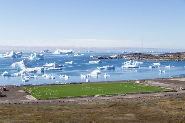 Voetbalveld met uitzicht op ijsbergen in Qeqertarsuaq, Groenland