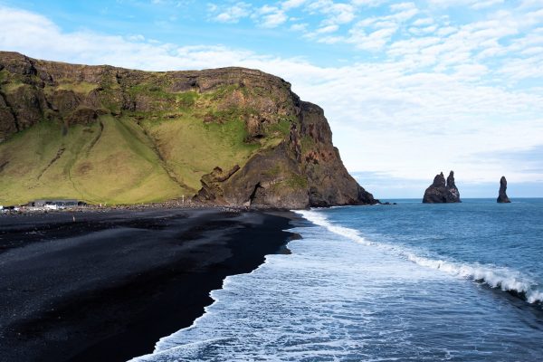 Luchtfoto van Reynisfjara beach, zwart strand en bergen in zee.