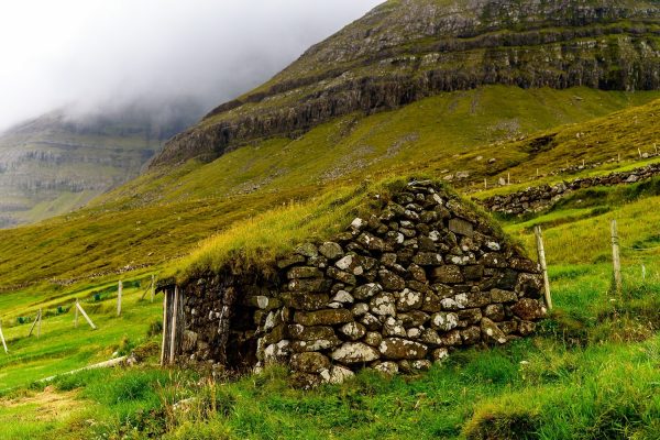 Stenen huisje met grasdak op het eiland Sandoy op de Faeröer eilanden