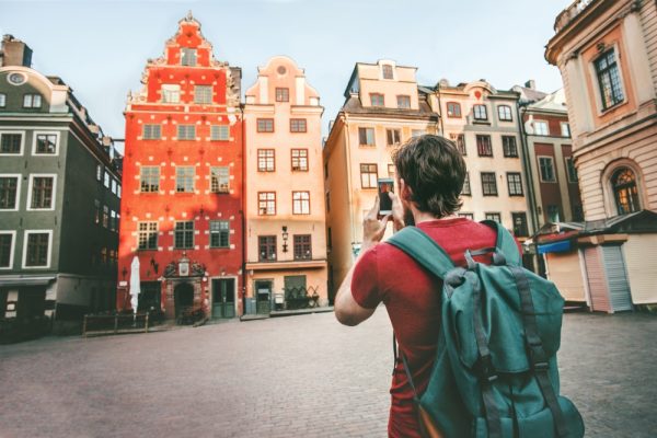 Toerist maakt foto van gekleurde huizen Stortoget, Stockholm, Zweden